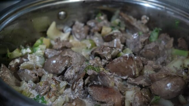 Chicken liver with fried celery, vegetables. Preparation in saucepan, with savory sauce. Healthy food. Commercial kitchen