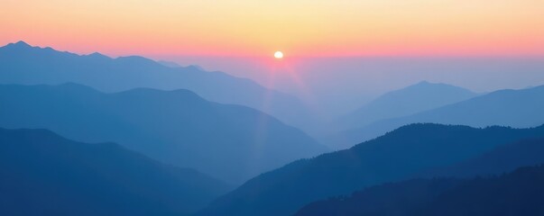Obraz premium Misty dawn breaks over layered blue mountains under a soft gradient sky, peaceful, foggy