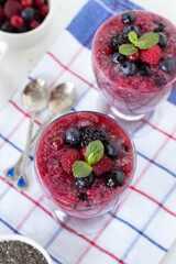 Chia seed pudding with frozen berries and fresh mint leaf for breakfast. Top view. Healthy raw vegan food.