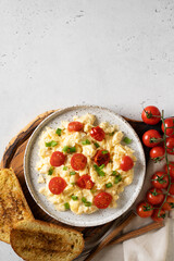 Scrambled eggs with onion and tomatoes on plate