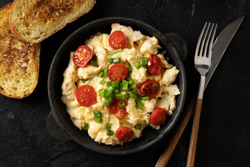 Scrambled eggs with onion and tomatoes on plate