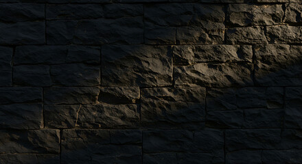  A black stone wall with a rough, textured surface.