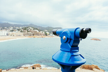 Paid blue telescope for tourists to view the beach.