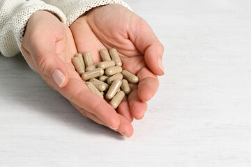 Female hands with herbal capsules
