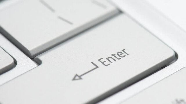 Finger pressing Enter button on a laptop keyboard