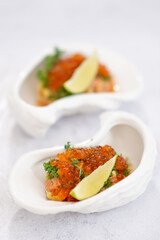 Salmon tartare appetizer with caviar. Mini tartlets with red salmon caviar and smoked salmon, an appetizer idea for a festive table
