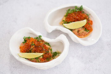 Salmon tartare appetizer with caviar. Mini tartlets with red salmon caviar and smoked salmon, an appetizer idea for a festive table