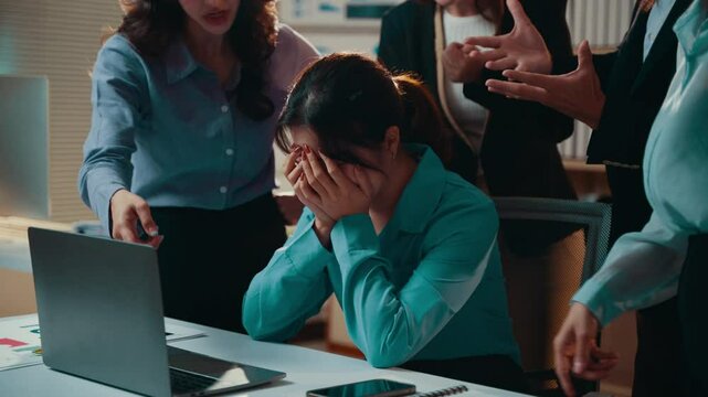 Asian businesswoman getting scolded by colleagues at work
