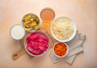 Fermented vegetables such as sauerkraut, pickled tomatoes, carrots, kimchi are displayed alongside a glass of kombucha and yogurt, highlighting the importance of probiotics for gut health