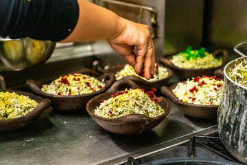 Kitchen Assistant Preparing Ceramic Bowls with Rice and Spices