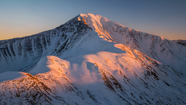 Majestic snow-capped mountain peak at sunrise
