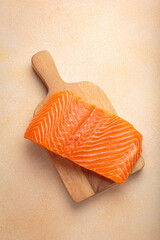 Fresh salmon fillet on wooden board, ready for delicious meal preparation and cooking. Healthy omega 3 source