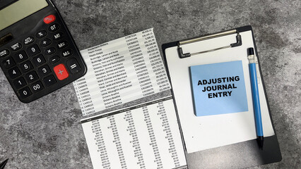 Concept of Adjusting Journal Entry write on sticky notes isolated on Wooden Table.