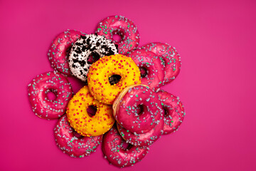 Colorful donuts on a pink background
