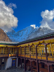 Interior of the courtyard of a Nepalese monastery with snowy mountains in the background