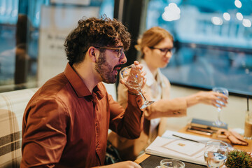 Two colleagues in a relaxed business setting engage in conversation while enjoying drinks. The setting appears informal, promoting a friendly work environment and collaborative discussion.