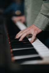 Obraz premium A focused view of a musician's hands playing piano, emphasizing talent, passion, and practice in music creation. The atmosphere suggests a rehearsal or casual performance in a creative environment.