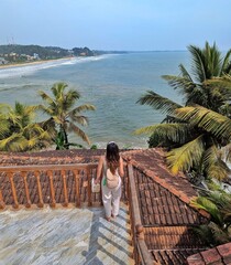 A woman stands at the edge of a balcony, overlooking the stunning coastline near Galle, Sri Lanka