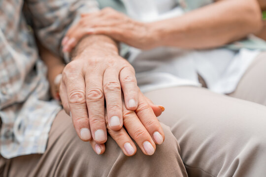 Close up of senior couple park and holding hands for bonding support and marriage together outdoors. Retirement empathy and elderly man with woman in nature on bench for love compassion connection