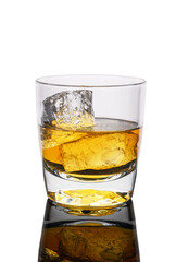 Golden drink in a clear glass with ice reflecting on a smooth surface