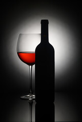 Captivating silhouette of wine bottle and glass reflecting elegance and intimacy in a dimly lit lounge