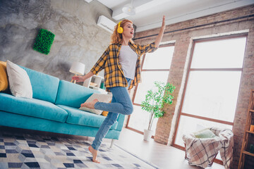 Full size photo of young blonde woman headphones dance listen music dressed yellow plaid outfit cozy day light home interior living room
