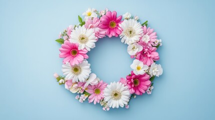 A beautifully crafted floral wreath arrangement showcases a delightful array of pink and white daisies set against a soft light blue background, creating a stunning visual contrast