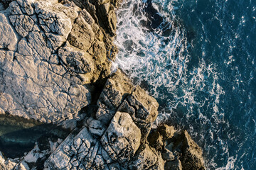 Sea surf hits the high rocky shore. Drone