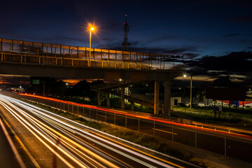 Fototapeta premium Traffic on the Highway and silhouette of a telecommunications antenna in Brazil during a sunset