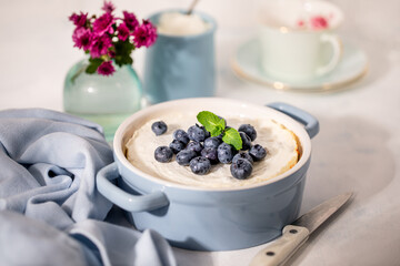 Homemade Cheesecake with blueberries in a blue ceramic mold.