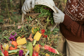 Zero waste, composting concept. Compost heap pile with bio waste. Farmer hands put weeds grass...