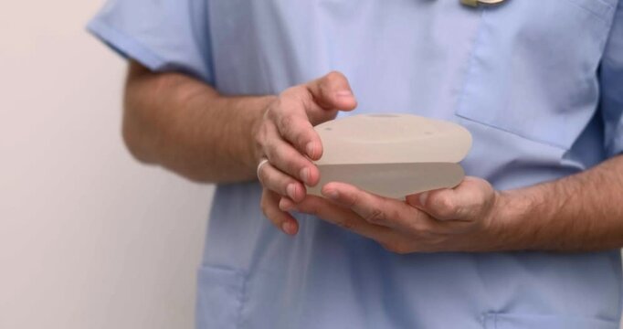 doctor holding breast enlargement implant in hands, plastic surgery concept, beauty enhancement, medical Mammoplasty and plastic surgery, mastopexy