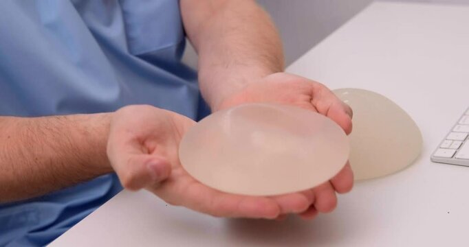 doctor holding breast enlargement implant in hands, plastic surgery concept, beauty enhancement, medical Mammoplasty and plastic surgery, mastopexy
