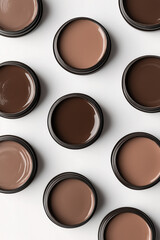 Fototapeta premium Mocha mousse, brown paint in cans, top view of circular containers, glossy texture, round lids