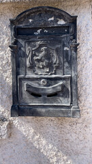 Vintage Metal Mailbox With A Lion Emblem Mounted On A Textured White Wall. Classic European Design For Secure Mail Delivery. Symbol Of Tradition And Historical Architecture In Urban Or Rural Settings.