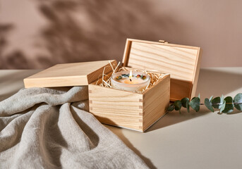 Handmade soy candle with dried flowers in a wooden gift box, cozy decor