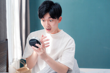 寝坊をして焦る若い男性