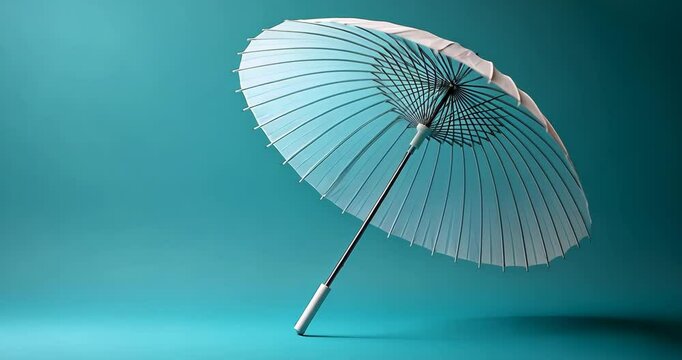 Static shot of a traditional white and teal parasol against a teal background.
