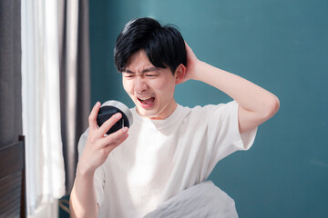 寝坊をして焦る若い男性