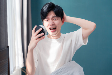 寝坊をして焦る若い男性
