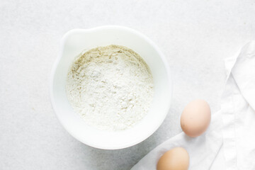 overhead view of All purpose flour in a bowl, top view of baking flour in a ceramic bowl