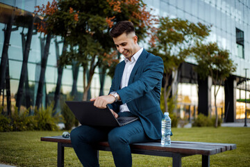 Man in Suit Sitting on Bench With Laptop