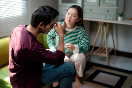 Stressed young man having headache and arguing with girlfriend at home - Powered by Adobe