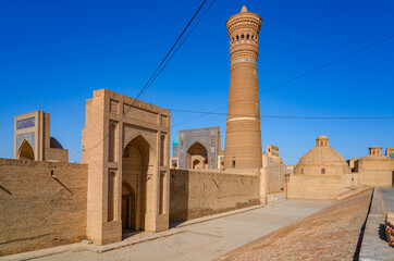 Fototapeta premium Po-i-Kalyan complex made of the Kalan Mosque , the Kalyan Minaret and the Mir-i Arab Madrasah in the historic old town of Bukhara in Uzbekistan, Central Asia