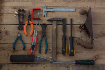 Old carpentry work tools on a brown wooden table background.