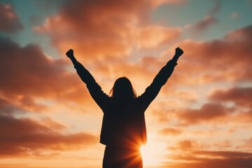 silhouette of person with arms raised at sunrise