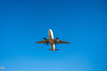 Underside view of an airplane flying through the sky, showcasing aviation technology, flight path, and the freedom of air travel.