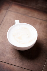 Cappuccino on dark wooden background. Soft focus. Close up.