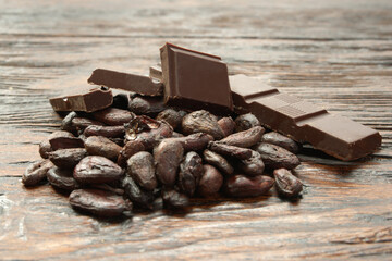 Broken dark chocolate and cocoa beans on the table
