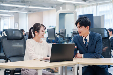 先輩社員から業務を教えてもらう新人の女性